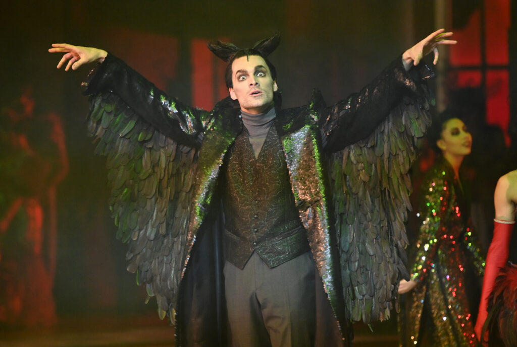Mann mit Flügeln breitet die Arme aus wie Dracula